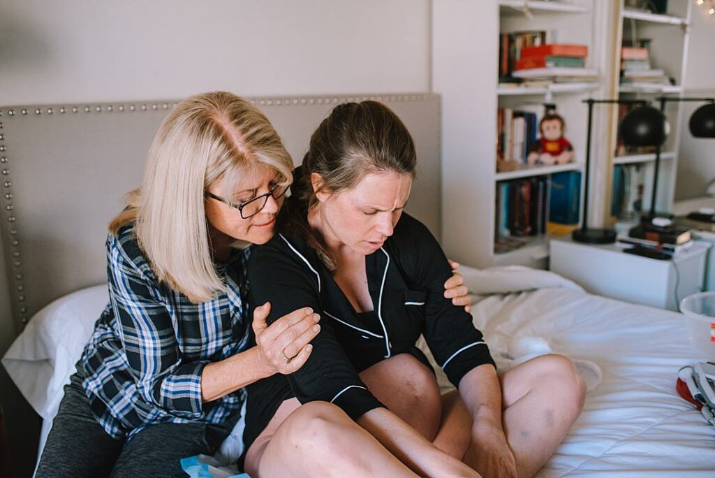 Mother is supporting her grown daughter who is in labor